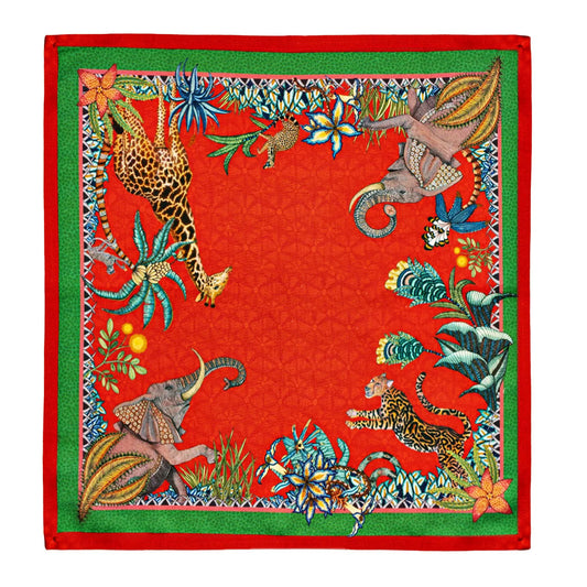 Sabie Forest Napkin featuring a vivid red background framed with green borders and illustrated African wildlife including a giraffe, elephants, and a tiger surrounded by lush tropical foliage.