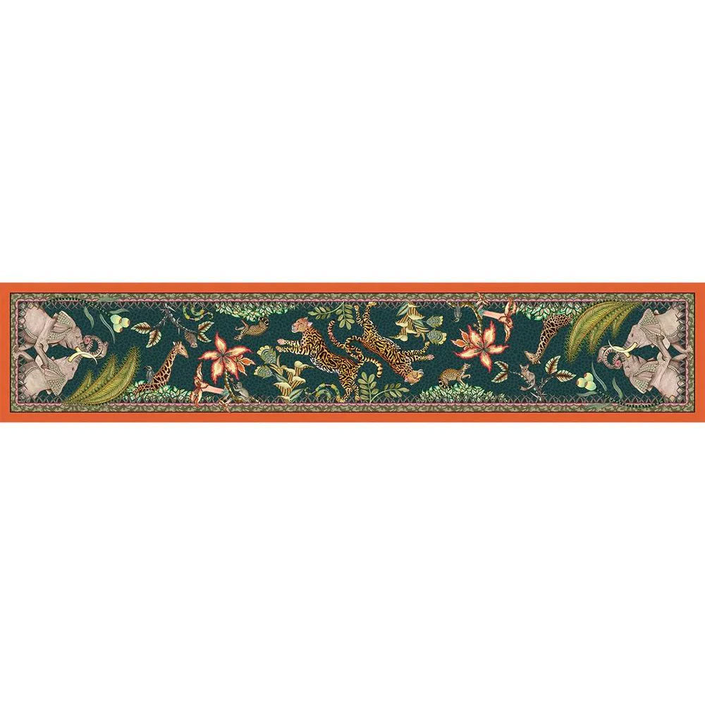 Full horizontal view of the Sabie Forest Table Runner Large laid flat, showing a dark teal base with intricate illustrations of elephants, leopards, a giraffe, and tropical flora bordered by an orange hem.