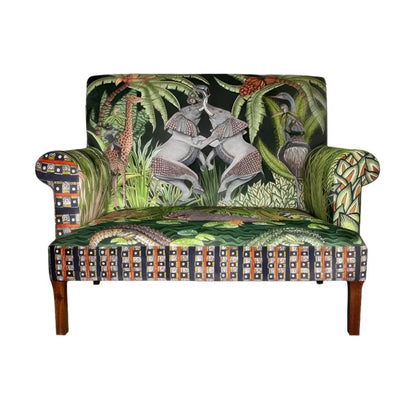 Front view of the Sabie Sofa featuring green-toned upholstery illustrated with safari animals, including two interactive elephants on the backrest, crocodiles on the seat cushion, and a geometric border.