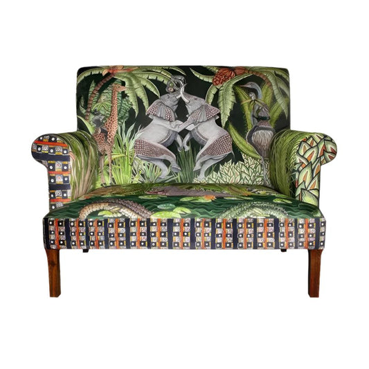 Front view of the Sabie Sofa featuring green-toned upholstery illustrated with safari animals, including two interactive elephants on the backrest, crocodiles on the seat cushion, and a geometric border.