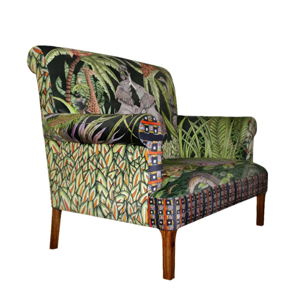 Three-quarter view of the Sabie Sofa showcasing its rolled arms, green jungle-themed safari upholstery, geometric accents, and dark wooden legs.