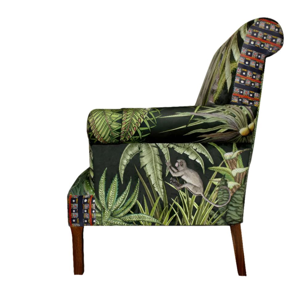 Side profile view of the Sabie Sofa displaying the outer arm upholstery with a monkey reaching through tropical green foliage.