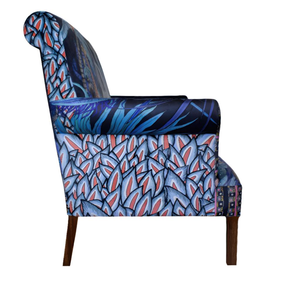 Side profile view of the Sabie Sofa displaying the outer arm upholstery with tropical blue leaves.