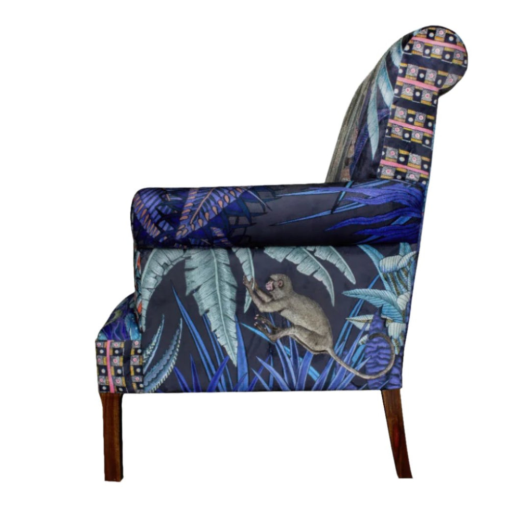 Side profile view of the Sabie Sofa displaying the outer arm upholstery with a monkey reaching through tropical blue leaves.