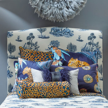 Safari Spot Pillow styled on a bed with coordinated wildlife and safari-inspired pillows in navy, yellow, blue, and neutral tones.