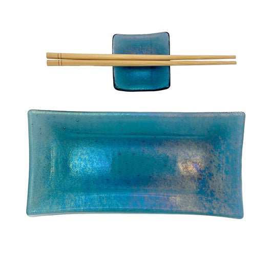 Handmade turquoise glass sushi set featuring a rectangular serving plate, matching square sauce dish, and a pair of light wood chopsticks on a white background.