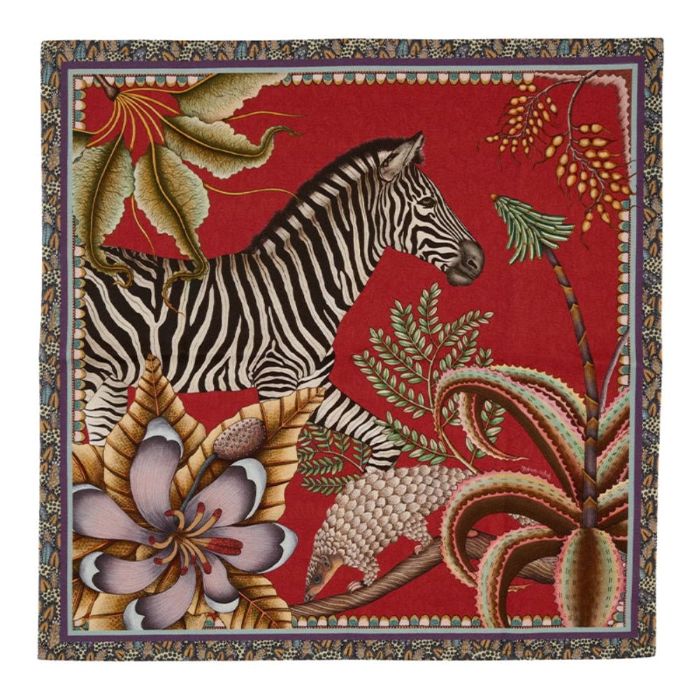 Thanda Stripe napkin in royal red with zebra, pangolin, gardenias, aloes, and patterned border.