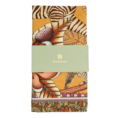 Folded Thanda Stripe napkins in flame orange showing zebra, pangolin, botanical details, and Ardmore packaging.