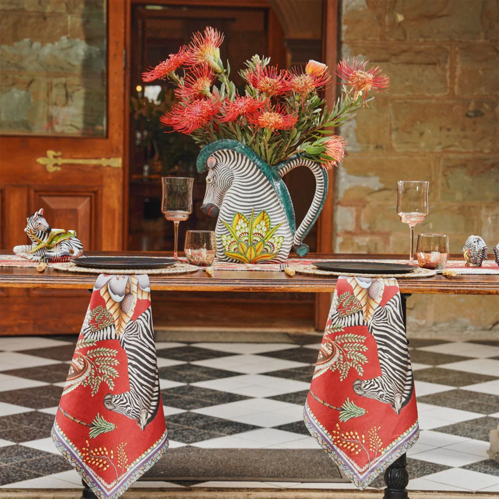 Thanda Stripe napkins styled on a dining table with zebra-themed decor and floral centerpiece.