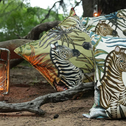 Thanda Stripe pillows styled outdoors with zebra print, botanical details, and lantern.