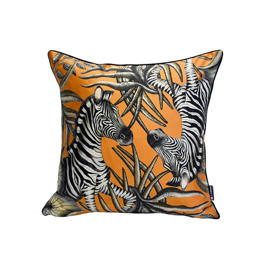 Thanda Stripe Pillow featuring two illustrated zebras surrounded by bold black and cream tropical foliage on a warm orange background.