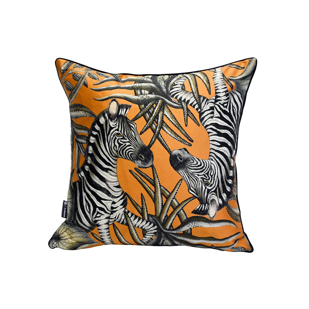 Thanda Stripe Pillow shown from a slightly different angle, featuring a pair of zebras among layered black and cream botanical leaves on an orange background.