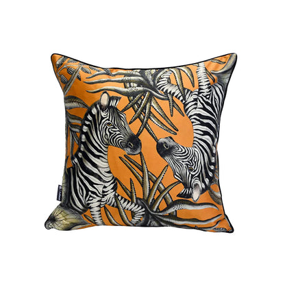 Thanda Stripe Pillow shown from a slightly different angle, featuring a pair of zebras among layered black and cream botanical leaves on an orange background.