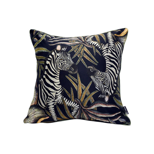Thanda Stripe Pillow featuring two illustrated zebras surrounded by layered botanical foliage in cream, olive, gold, and muted earthy tones against a black background.
