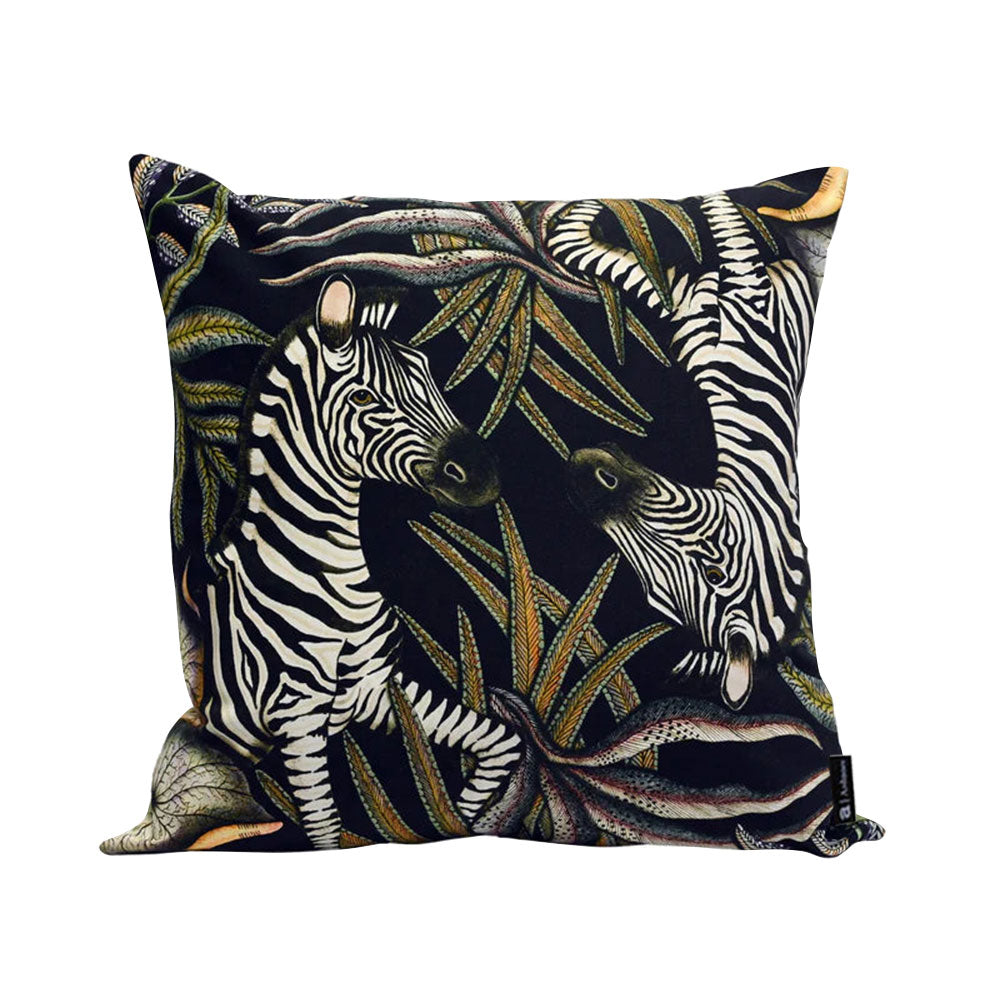 Thanda Stripe Pillow featuring two illustrated zebras surrounded by layered cream, olive, gold, and earthy botanical foliage on a deep navy background.