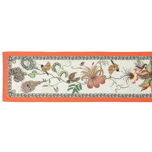 Full view of a long Ardmore table runner decorated with birds, nests, oversized flowers, foliage, and a bright coral-orange border.