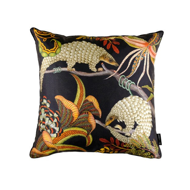 Square Ardmore decorative pillow featuring two illustrated pangolins among colorful tropical flowers, branches, and foliage on a black background.